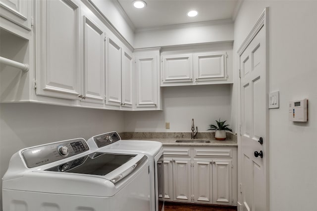 clothes washing area with cabinets, separate washer and dryer, crown molding, and sink