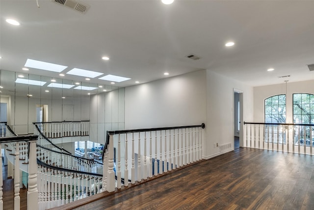 corridor with a skylight and dark hardwood / wood-style flooring