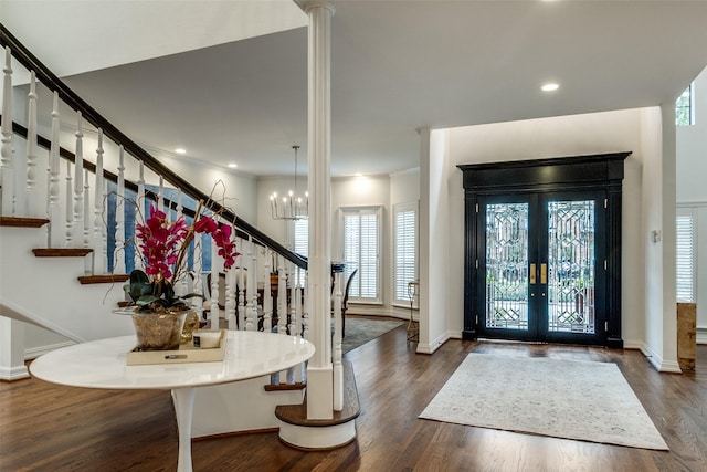 entryway with dark hardwood / wood-style flooring, french doors, crown molding, and a chandelier