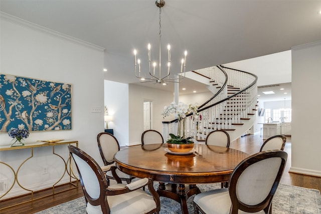 dining area with an inviting chandelier, crown molding, and hardwood / wood-style floors