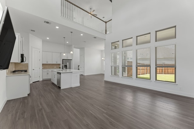 kitchen featuring a center island with sink, appliances with stainless steel finishes, ceiling fan, pendant lighting, and white cabinets