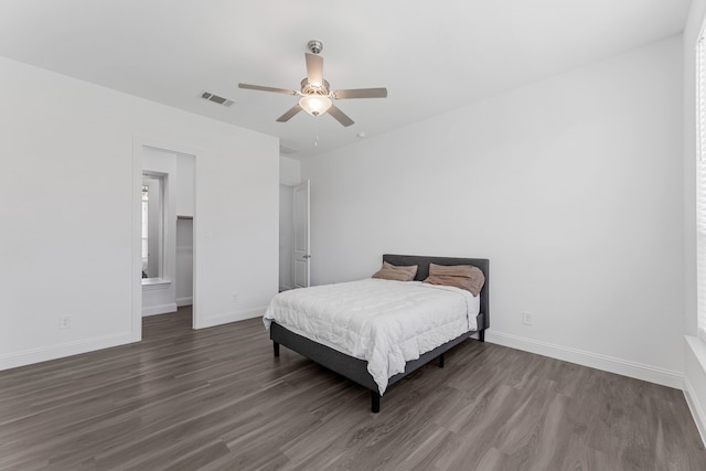 bedroom featuring ceiling fan, dark hardwood / wood-style flooring, and connected bathroom