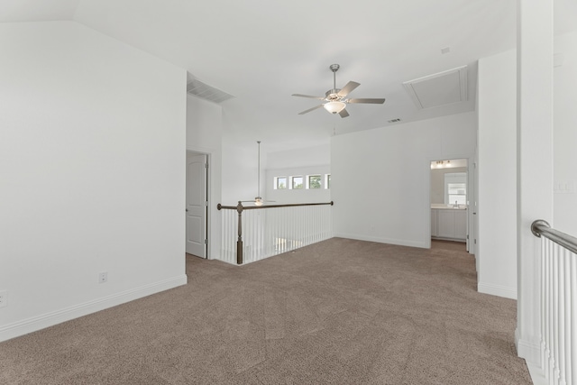 carpeted spare room featuring vaulted ceiling and ceiling fan