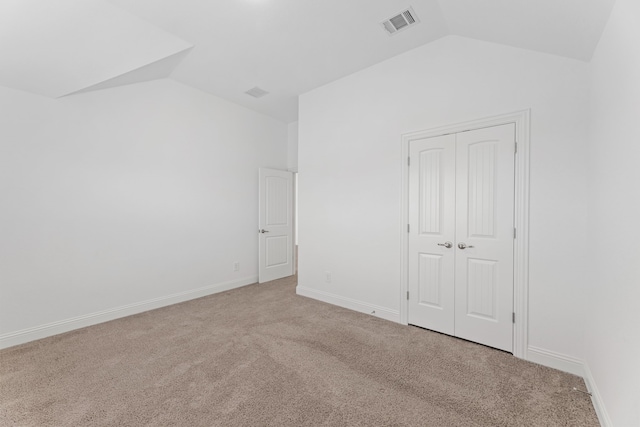 interior space featuring vaulted ceiling and light carpet