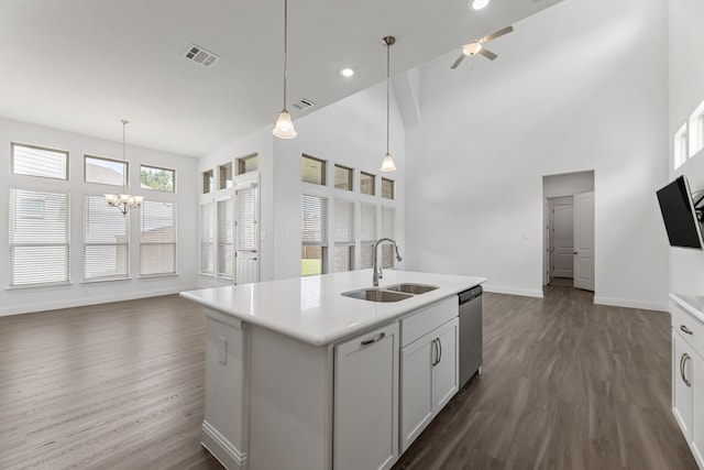 kitchen featuring sink, decorative light fixtures, stainless steel dishwasher, dark hardwood / wood-style flooring, and a kitchen island with sink