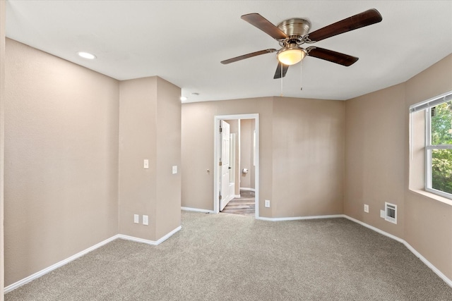 carpeted spare room featuring ceiling fan