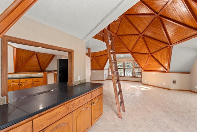 kitchen with lofted ceiling, light tile patterned floors, and wood ceiling