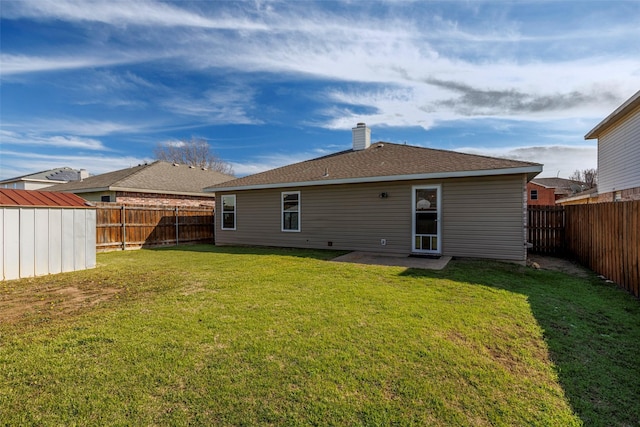 rear view of house featuring a yard and a shed