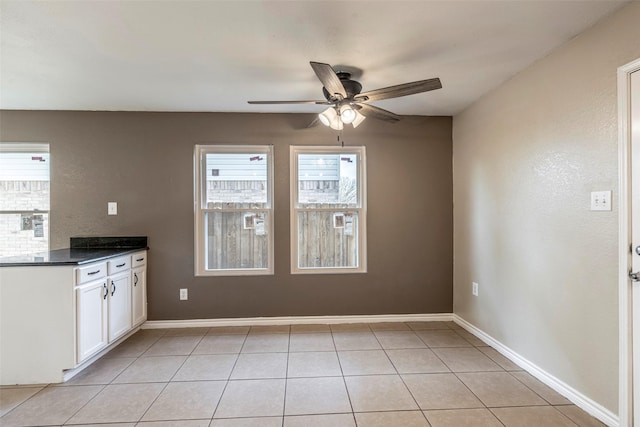 kitchen with white cabinets, ceiling fan, and light tile patterned floors