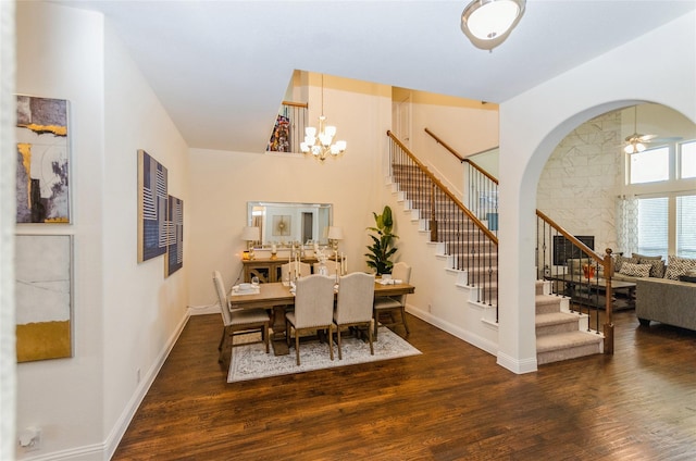 dining area featuring ceiling fan with notable chandelier and dark wood-type flooring