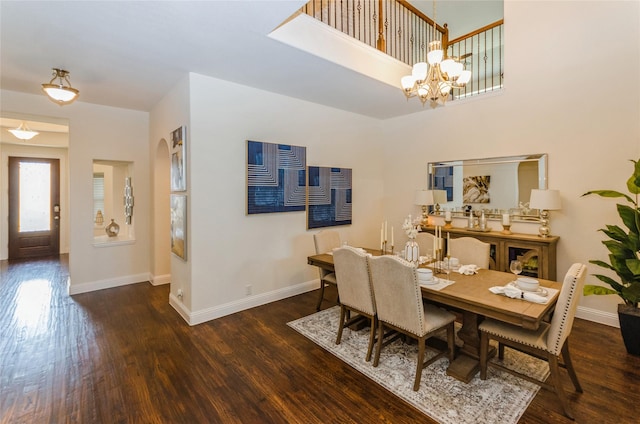 dining room with dark wood-type flooring and an inviting chandelier