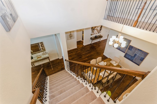 stairs with a notable chandelier and hardwood / wood-style flooring