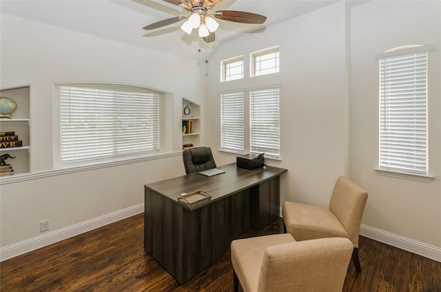 office area featuring lofted ceiling, built in shelves, dark wood-type flooring, and ceiling fan