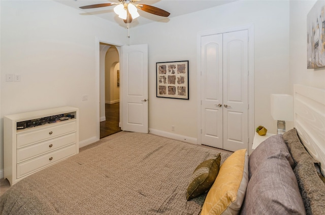 carpeted bedroom featuring ceiling fan and a closet