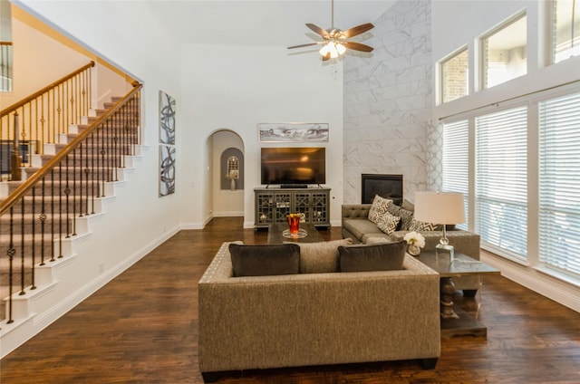 living room featuring high vaulted ceiling, ceiling fan, and dark wood-type flooring