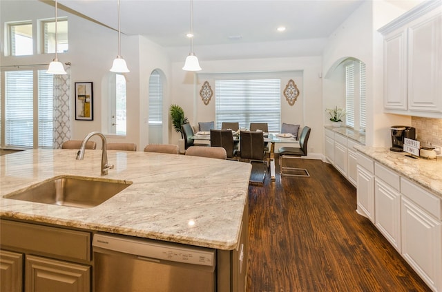 kitchen with light stone countertops, dishwasher, pendant lighting, white cabinetry, and sink