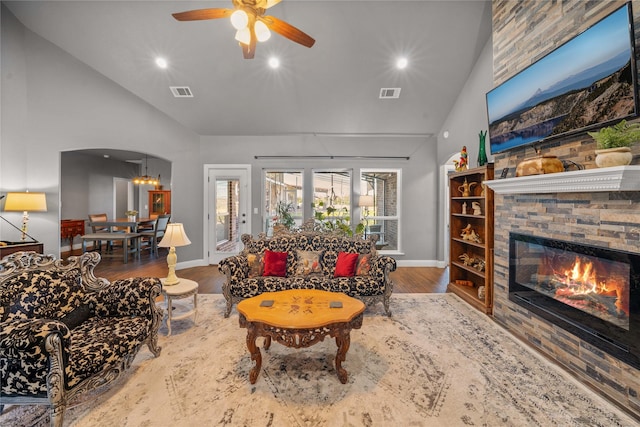 living room featuring a fireplace, high vaulted ceiling, ceiling fan, and hardwood / wood-style flooring