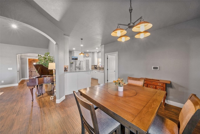 dining space featuring a textured ceiling and dark hardwood / wood-style flooring