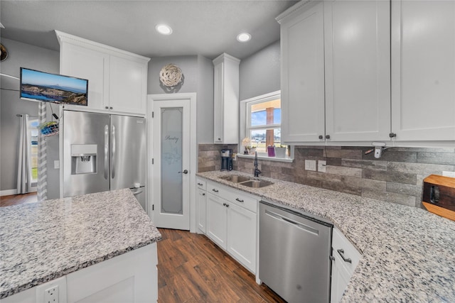 kitchen with stainless steel appliances, white cabinetry, and sink