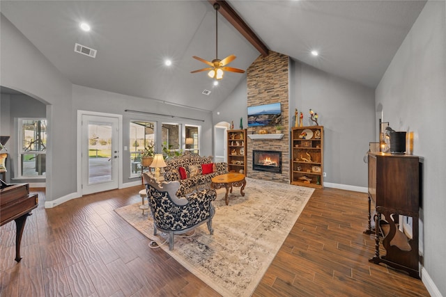 living room with a stone fireplace, ceiling fan, high vaulted ceiling, dark hardwood / wood-style floors, and beam ceiling