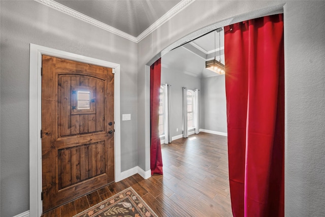 foyer entrance featuring ornamental molding and dark hardwood / wood-style floors