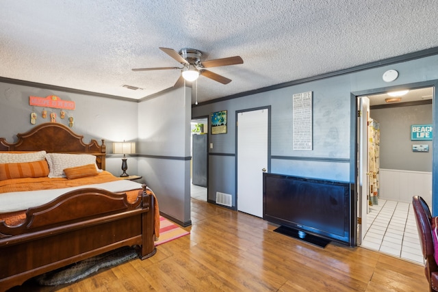 bedroom with ornamental molding, a textured ceiling, ceiling fan, and light hardwood / wood-style floors