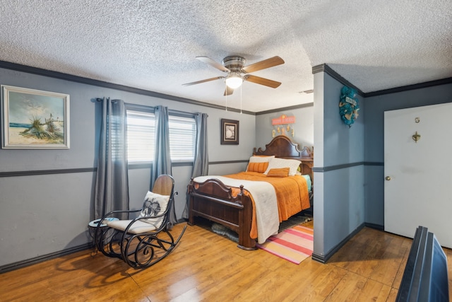 bedroom featuring ceiling fan, ornamental molding, hardwood / wood-style floors, and a textured ceiling