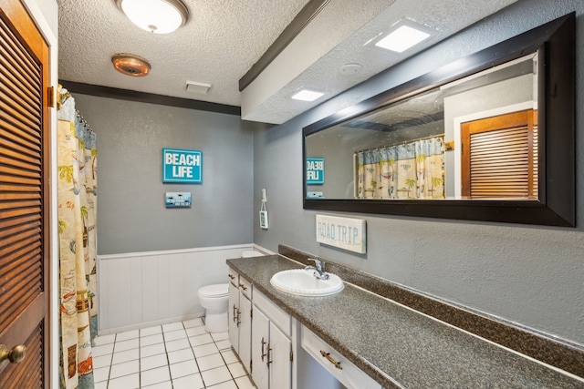 bathroom featuring wooden walls, a textured ceiling, toilet, tile patterned floors, and vanity