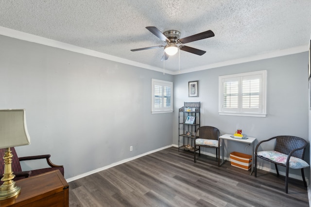 sitting room featuring dark hardwood / wood-style flooring, a textured ceiling, ceiling fan, and crown molding