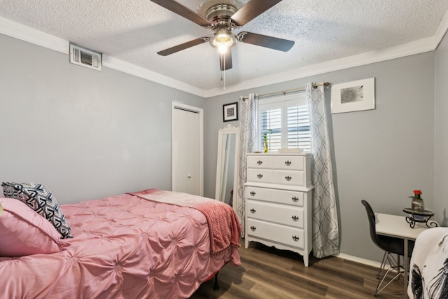 bedroom with ornamental molding, a textured ceiling, dark wood-type flooring, and ceiling fan