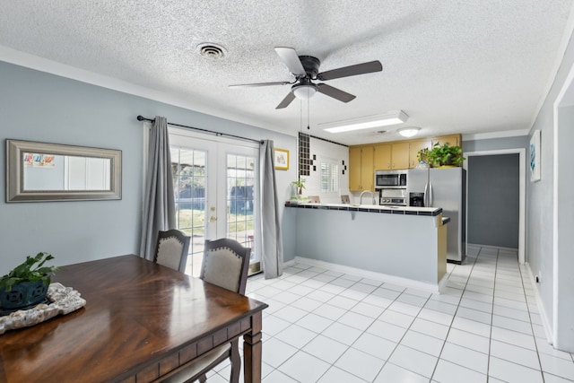 kitchen with kitchen peninsula, french doors, light tile patterned floors, appliances with stainless steel finishes, and ceiling fan