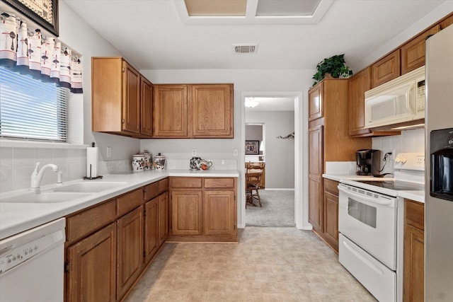 kitchen with white appliances, decorative backsplash, and sink