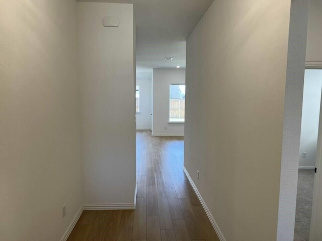 corridor with hardwood / wood-style flooring