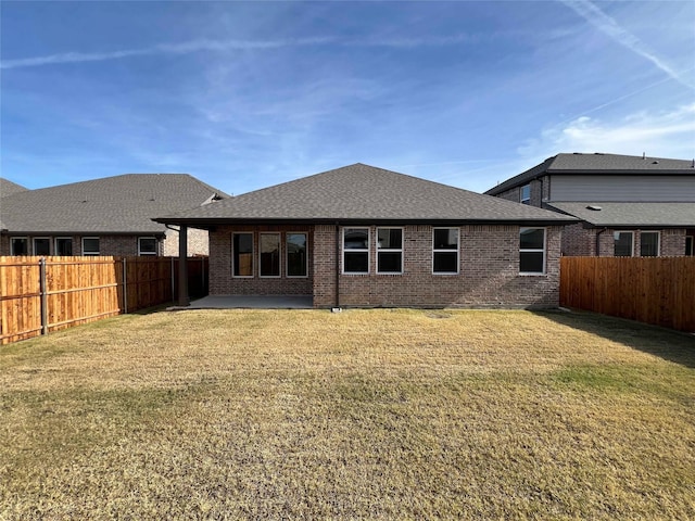 rear view of property featuring a patio area and a lawn