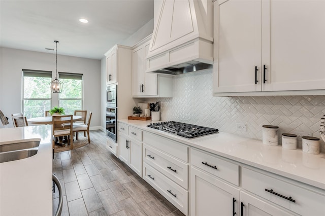 kitchen with white cabinets, stainless steel appliances, tasteful backsplash, and custom exhaust hood