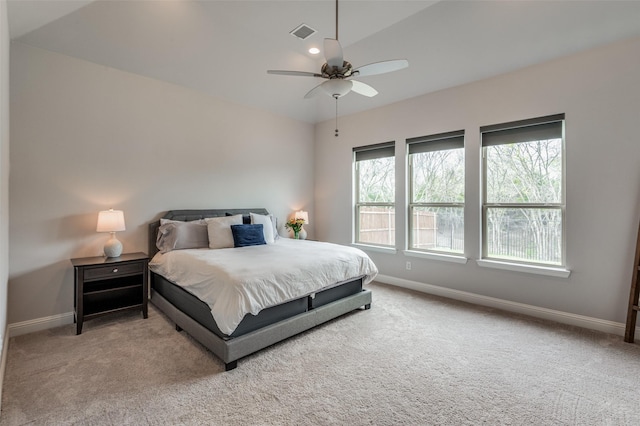 carpeted bedroom with ceiling fan, vaulted ceiling, and multiple windows