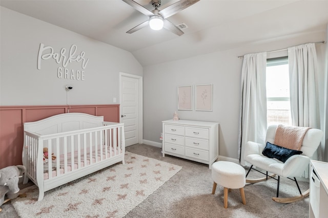 bedroom with ceiling fan, light colored carpet, lofted ceiling, and a nursery area