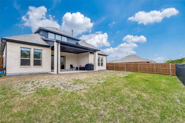 rear view of property with a lawn and a patio