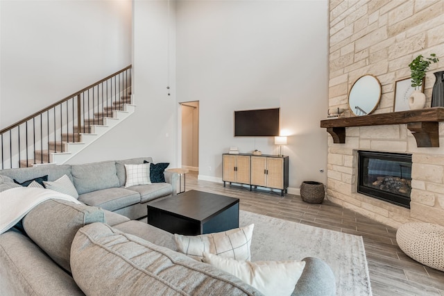 living room featuring a high ceiling and a stone fireplace