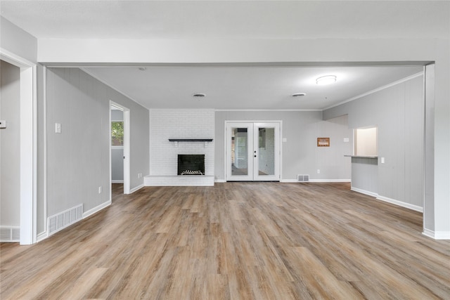 unfurnished living room with a fireplace, light wood-type flooring, and ornamental molding