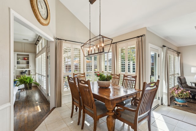 dining area with light tile patterned floors, lofted ceiling, and a notable chandelier