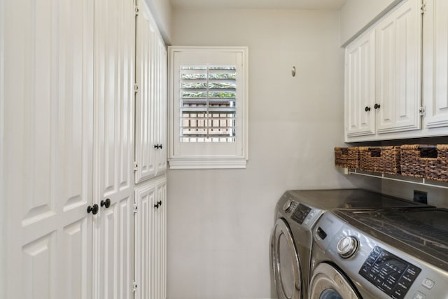 clothes washing area featuring washer and clothes dryer and cabinets