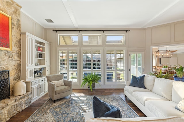 sunroom with an inviting chandelier and beamed ceiling