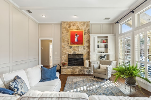 living room featuring ornamental molding, dark wood-type flooring, and a fireplace