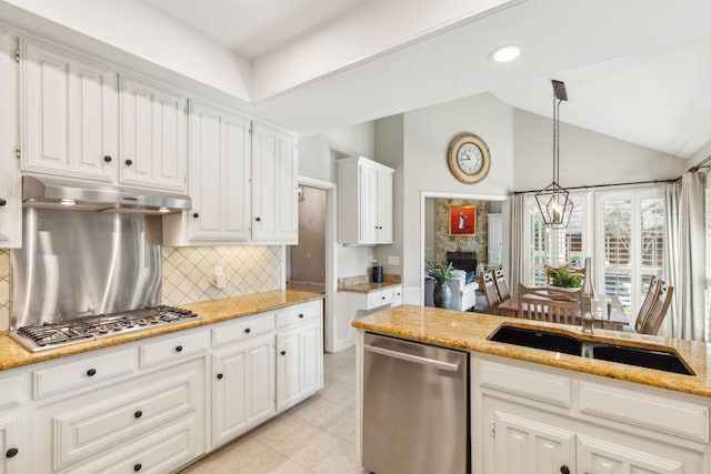 kitchen featuring appliances with stainless steel finishes, decorative backsplash, lofted ceiling, hanging light fixtures, and white cabinets