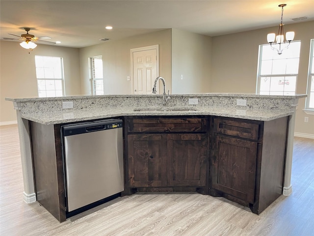 kitchen featuring stainless steel dishwasher, dark brown cabinetry, light wood-style floors, and a sink