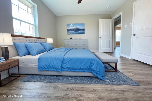 bedroom featuring ceiling fan, baseboards, and wood finished floors