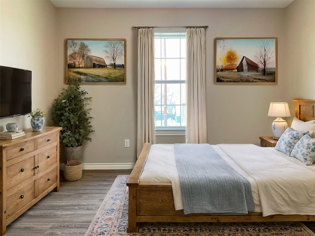 bedroom with wood finished floors and baseboards