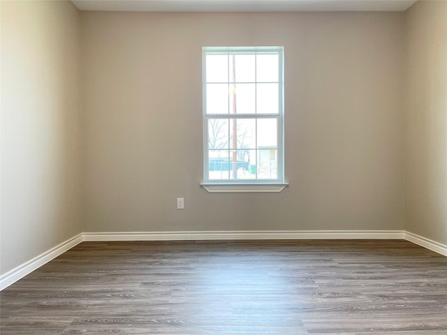 unfurnished room featuring baseboards and wood finished floors