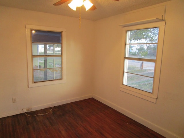 empty room with ceiling fan and dark hardwood / wood-style flooring